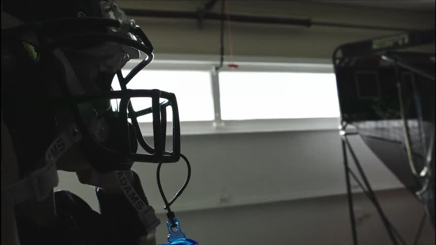 A boy places a football helmet on his head