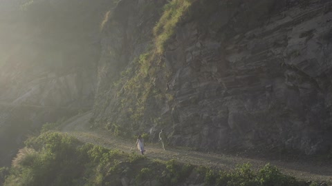 A couple walking along a cliff side