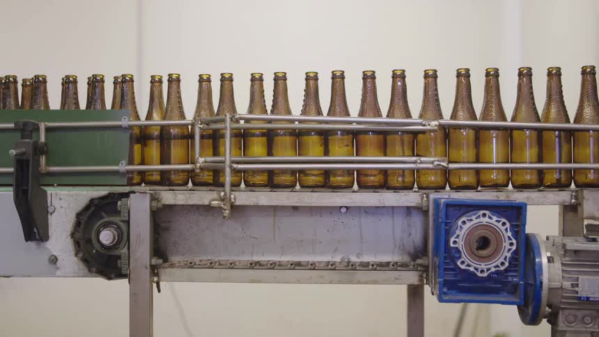 Brown glass bottles on a conveyor belt