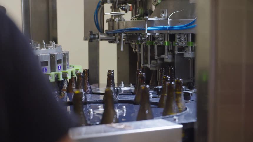 Brown glass bottles on a conveyor belt