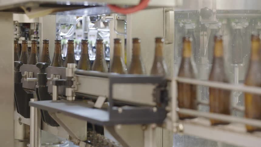 Brown bottles moving along an automated production line