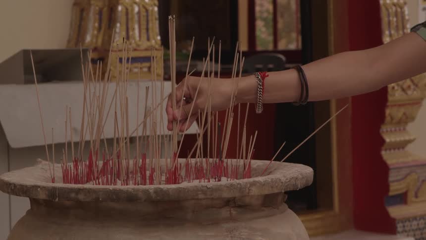 A person placing incense