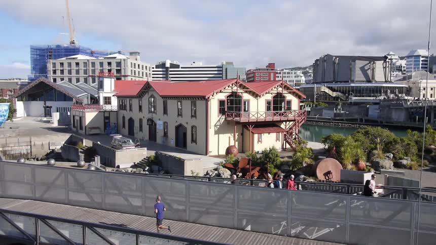 Person jogging  while others slowly stroll in a city