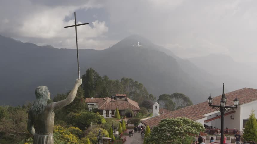 A statue on top of a hill overlooking a town