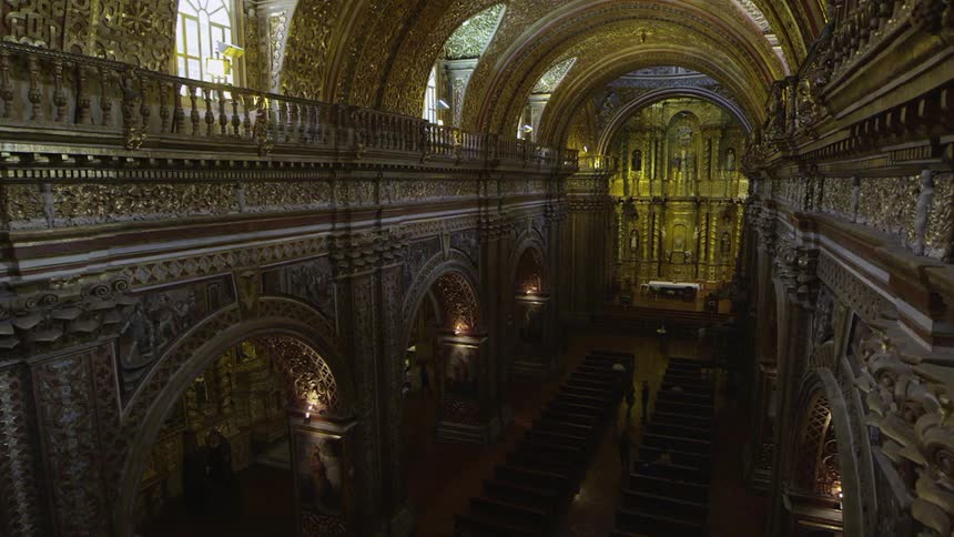 A cathedral has an ornate, gold-colored ceiling