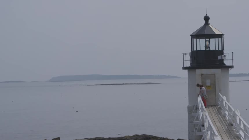 A lighthouse sits in waiting at the oceanfront
