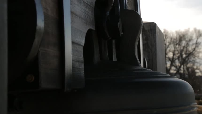 A large bell rocks gently back and forth