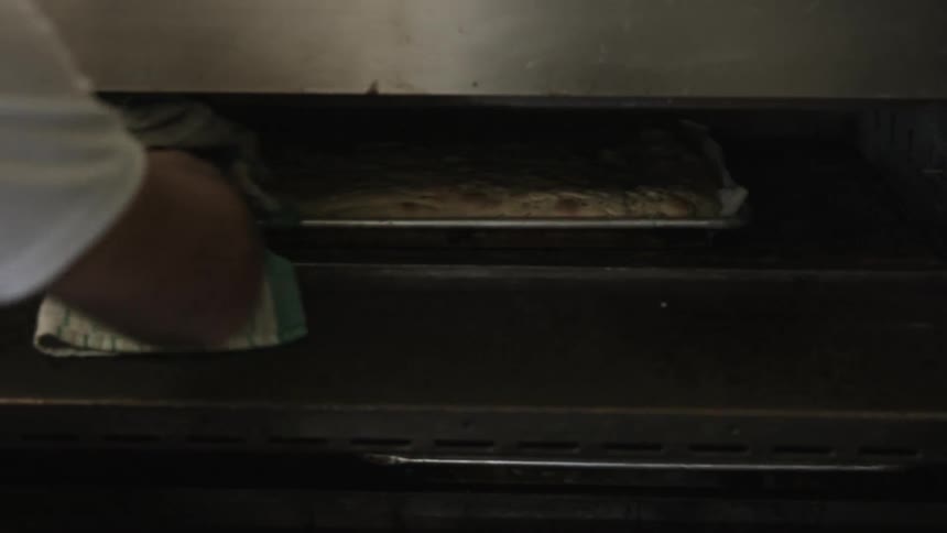 A person rotating things in an oven