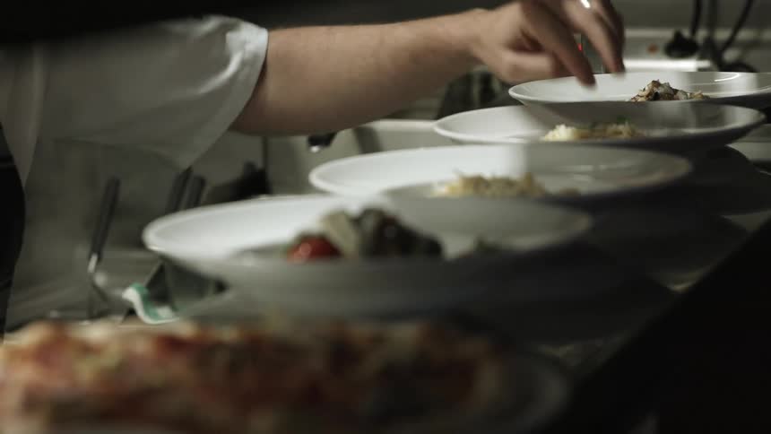 A line cook adding final touches to  dish