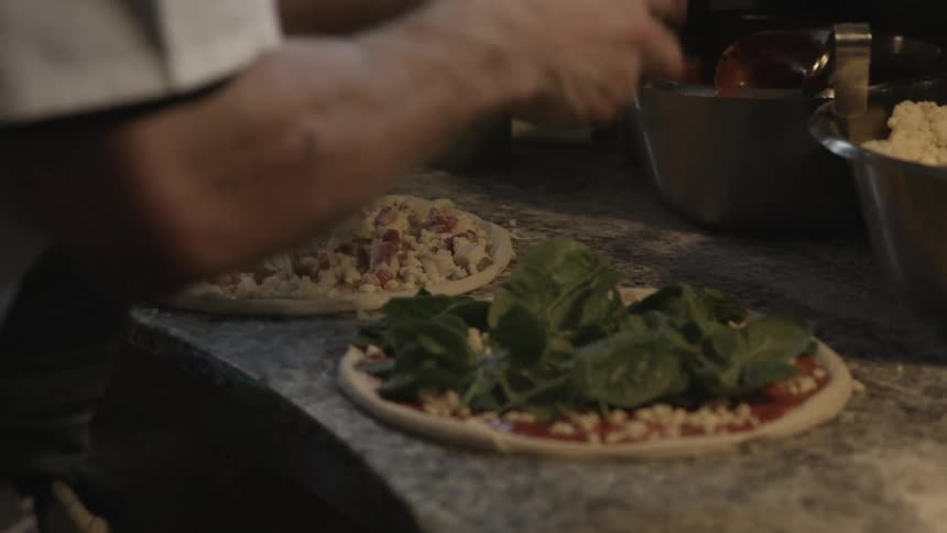 A person making pizzas