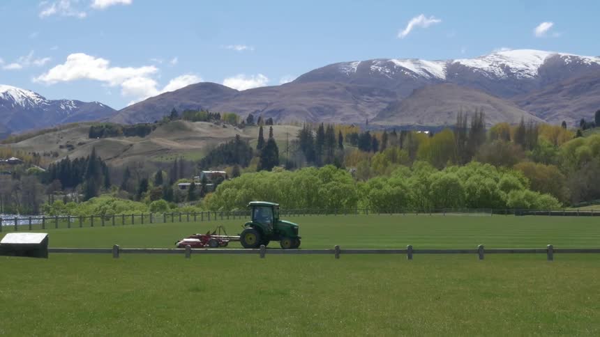 A tractor mowing grass in a field