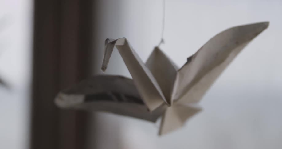 A view of a paper crane hanging on a string