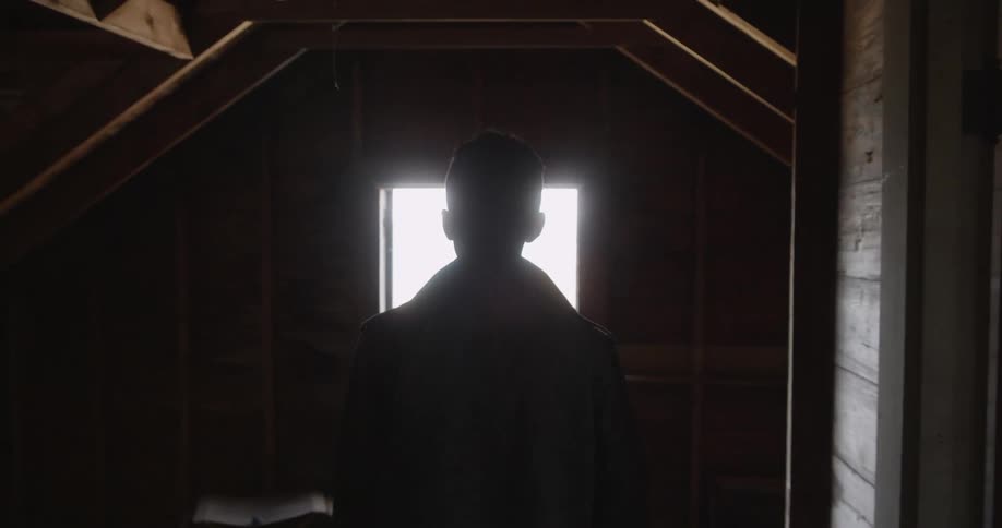 A man walks through a barn