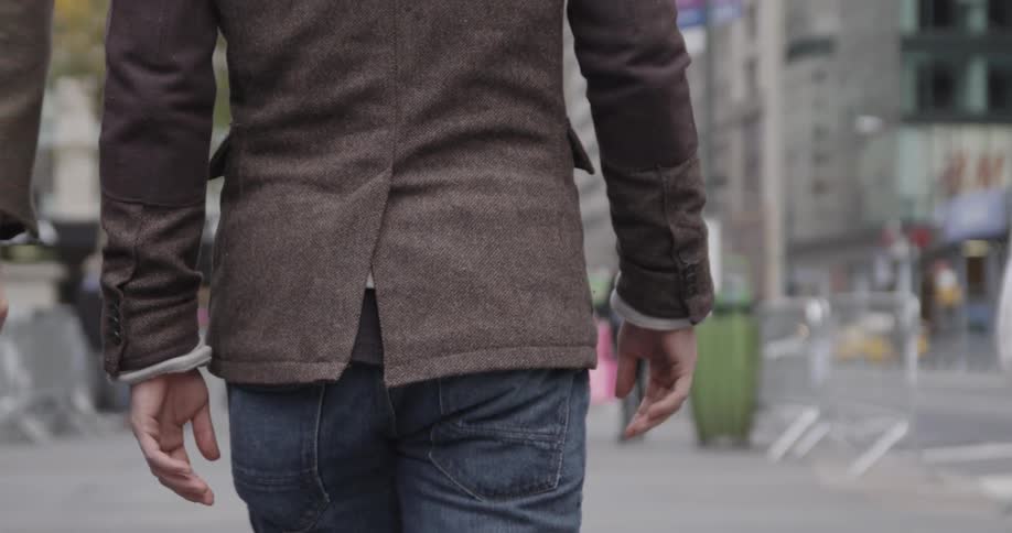 Pedestrians walk down a city sidewalk