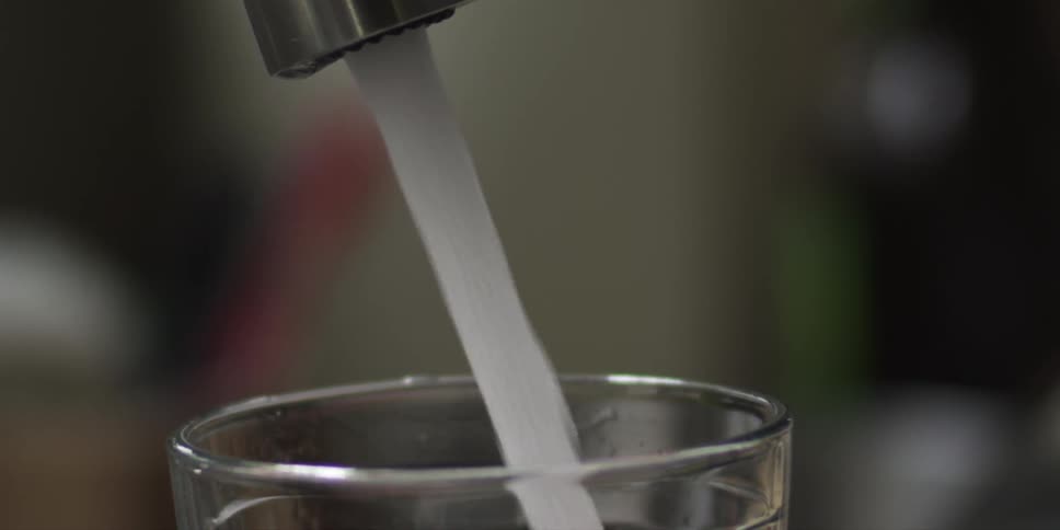 A person turning on a faucet