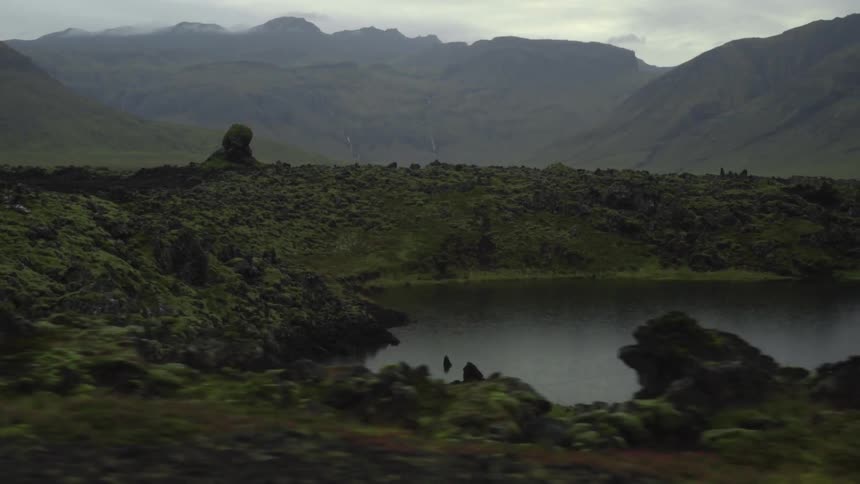 A view of the mountains and a body of water on a cloudy day