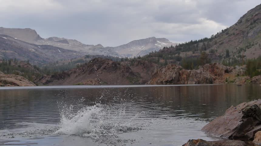 Clothed man diving into a lake