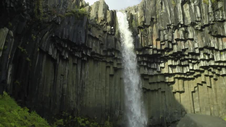 A waterfall crashing down into a rocky pool