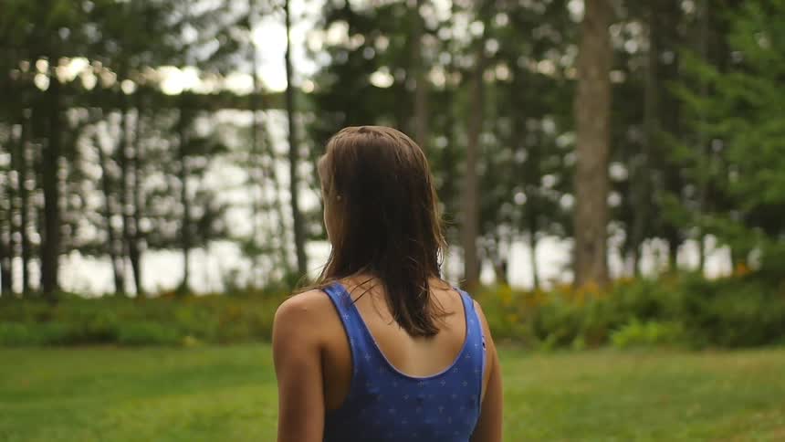 A woman in a vest top walking in a rural area