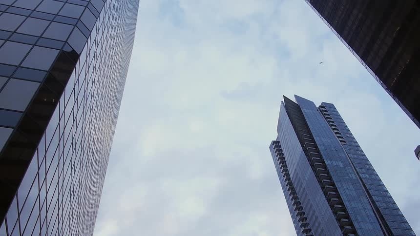 Three skyscrapers below a cloudy sky