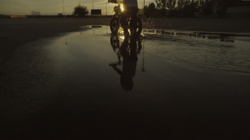 Kid riding their bike at sunset