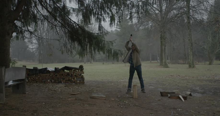 Man chops wood with an ax