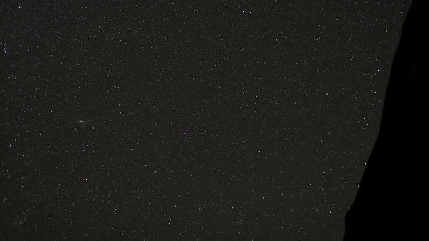 A timelapse view of the stars in the night sky, as one shooting star zips through