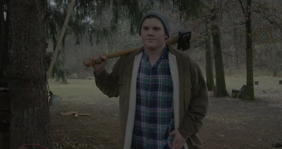Man walks in the woods with an ax
