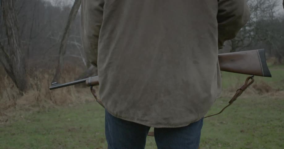A man is preparing to hunt in a field