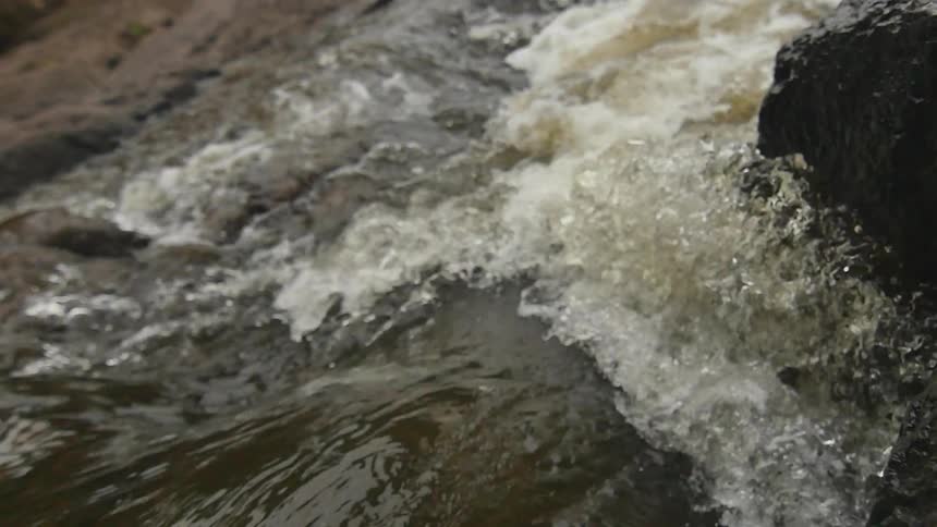Water rippling, flowing and crashing around rocks