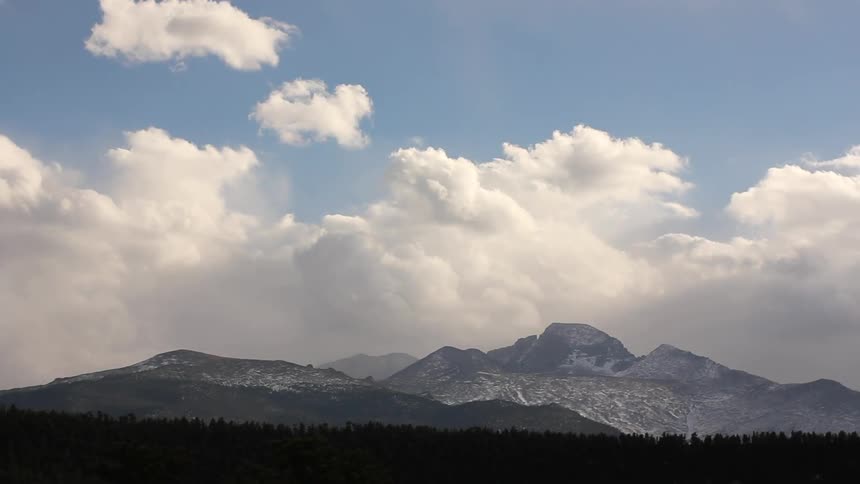 Timelapse of the clouds roaring over a mountain range off in the distance