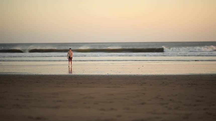 boy throwing rocks on the beach