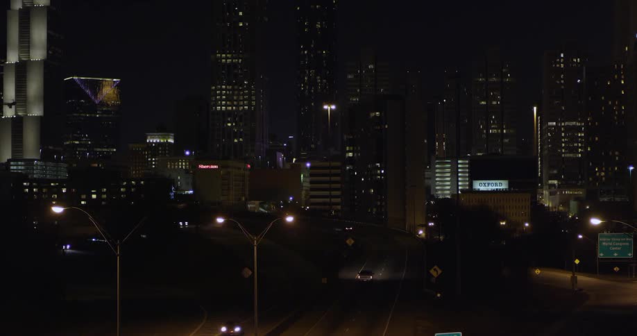 Cars drive through a city at night