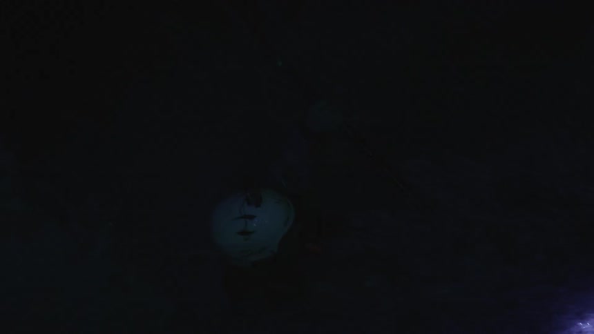 A kayaker paddles and flips at night