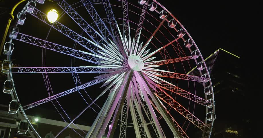 A ferris wheel lights up against the night sky