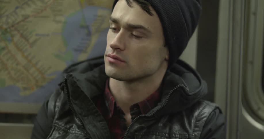Man with black hat riding a subway train