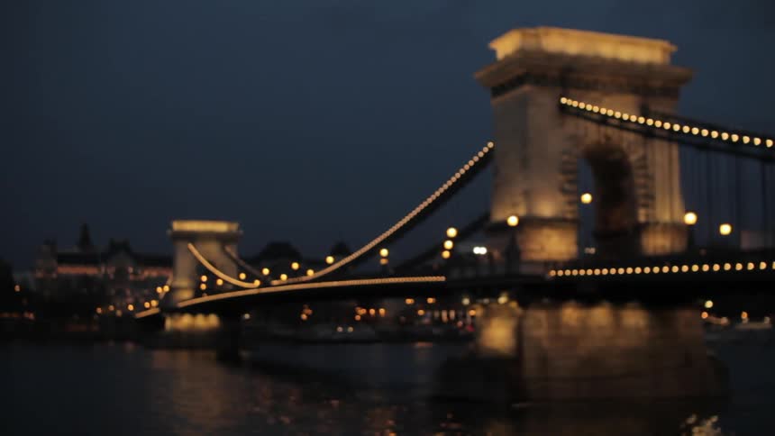 A bridge lights up at dusk