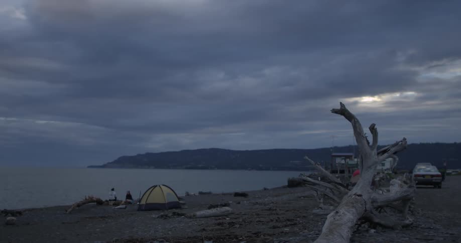 People camping on a shore on a cloudy day