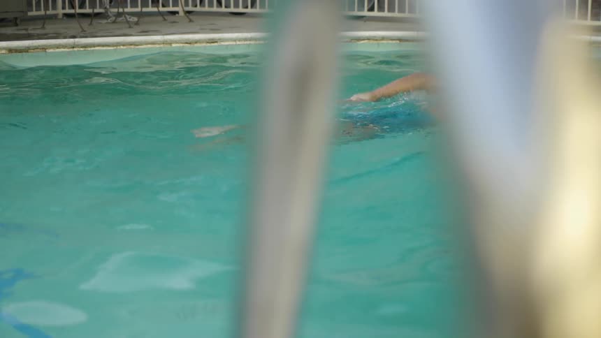 A person swims in a swimming pool