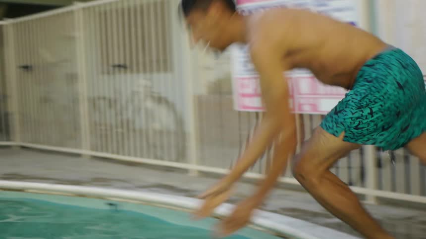 A man dives into a swimming pool