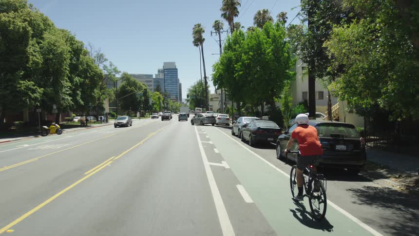 A bicyclist rides down a city street