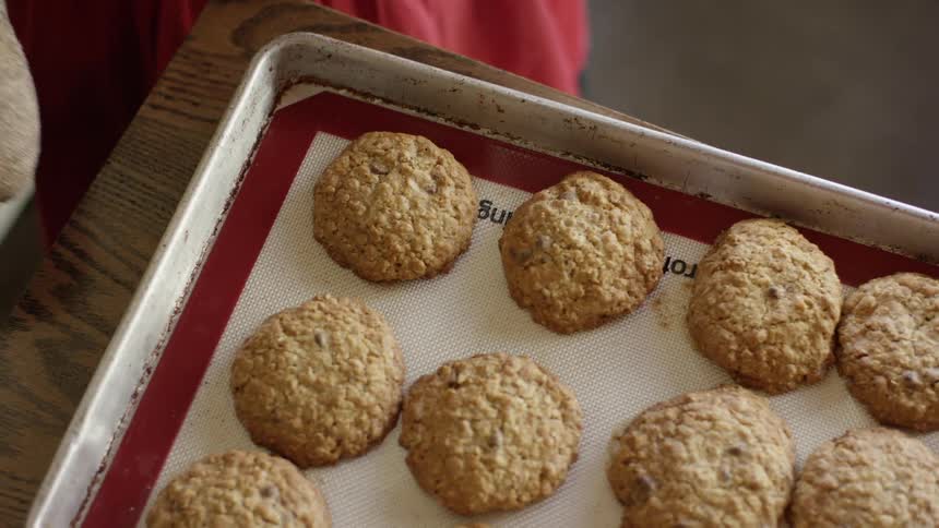 Woman puts cookie tray on table to cool