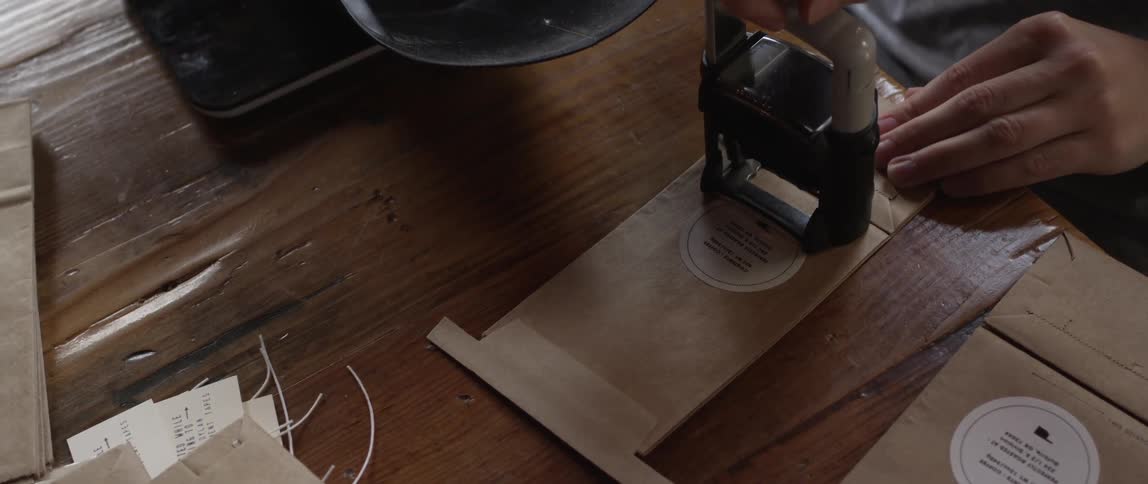 A woman stamps a paper bag