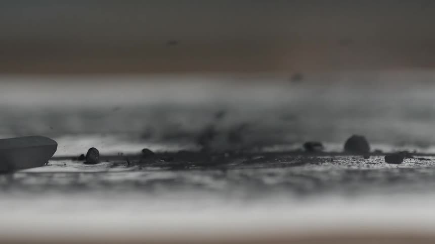 Charcoal is blown off a flat surface
